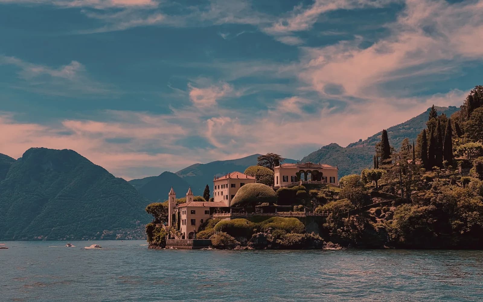 A house by the lake — House on the water at first light, still surface, mountains behind.